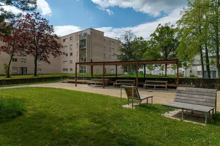 Des bancs dans un square arboré. 