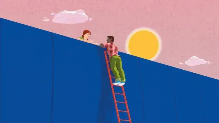 Deux personnes se tendent la main par-dessus un mur imaginaire. 