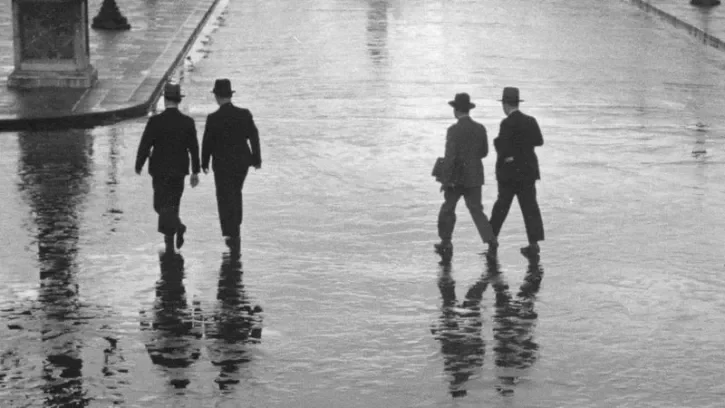 Des hommes traversent une place. 
