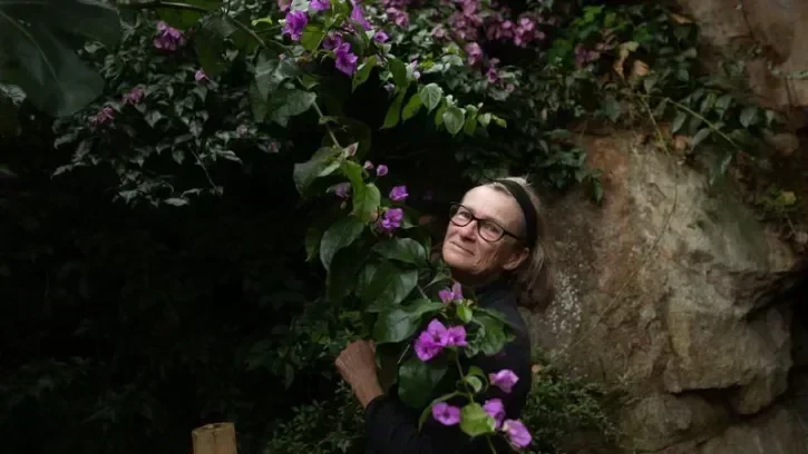 Une femme au mileu des fleurs de bougainvillier.
