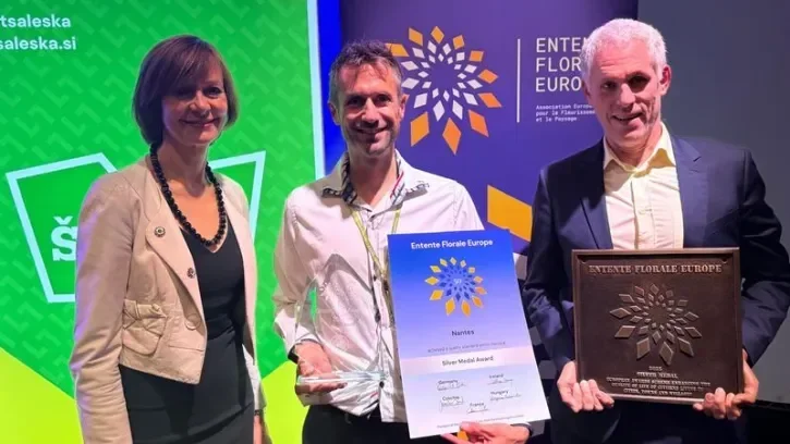 Trois personnes à la tribune lors de la remise du prix international des espaces 2025, en Slovénie.