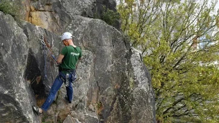 Un homme escalade la falaise du Jardin extraordinaire.