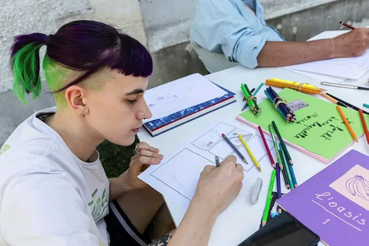 Une jeune fille en train de dessiner. 