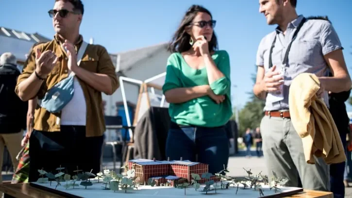 Des personnes devant une maquette du projet d'un nouvel équipement culturel nantais : le Port des arts nomades.