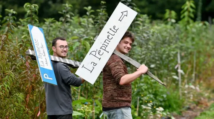 Les deux créateurs de la Pépinette portant les pancartes de cette nouvelle pépinière bio.