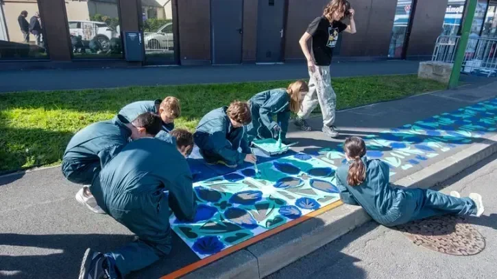 Des jeunes dessinent des motifs sur le parvis de la gare de Vertou.