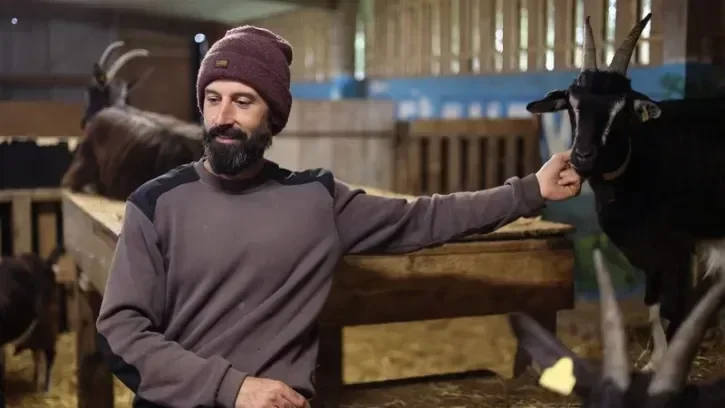 Un éleveur sous un hangar avec ses chèvres, à Vertou.