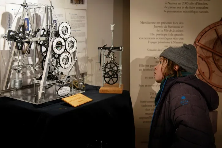 Un enfant regarde un outil d'astronomie. 