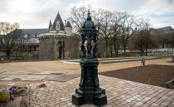 Une fontaine en fonte, vert foncé, dans le nouveau jardin près du château.