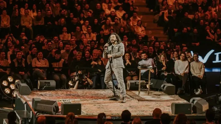 Un humoriste devant une salle comble.