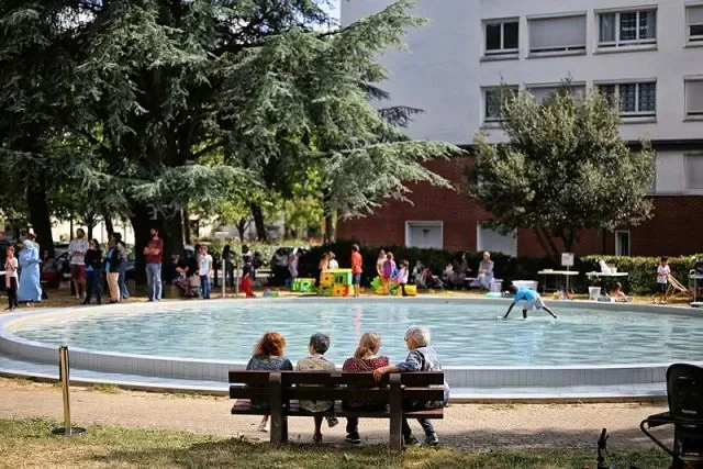 Quatre personnes assises sur un banc face à une pateaugoire. 