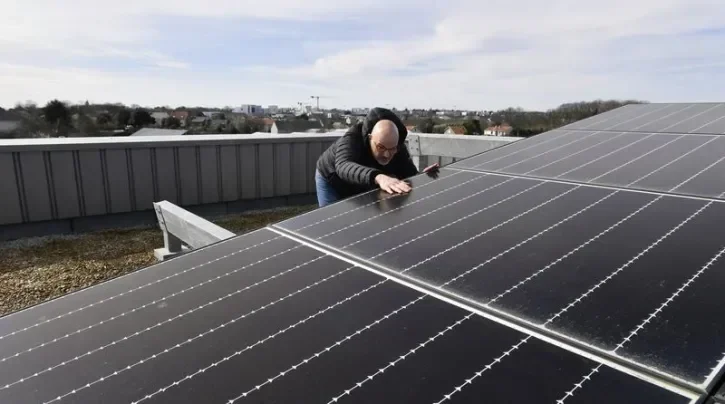Un homme inspecte des panneaux solaires.