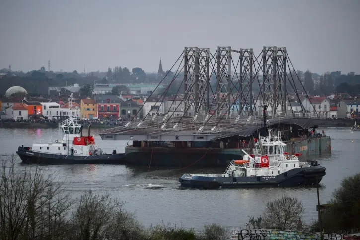 La barge effectue son demi tour au large de Trentemoult entouré de deux remorqueurs. 