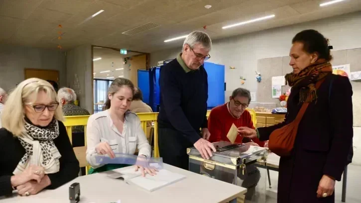 Une électrice s'apprête à déposer son bulletin de vote dans l'urne dans un bureau de vote de l'école Alice Guy à Nantes.