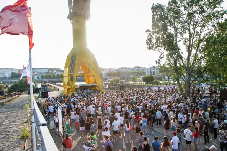 Des personnes dansent devant un DJ installé sous la Grue jaune.