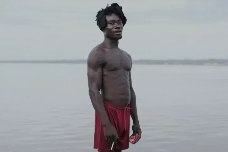Un homme pose devant un fleuve.