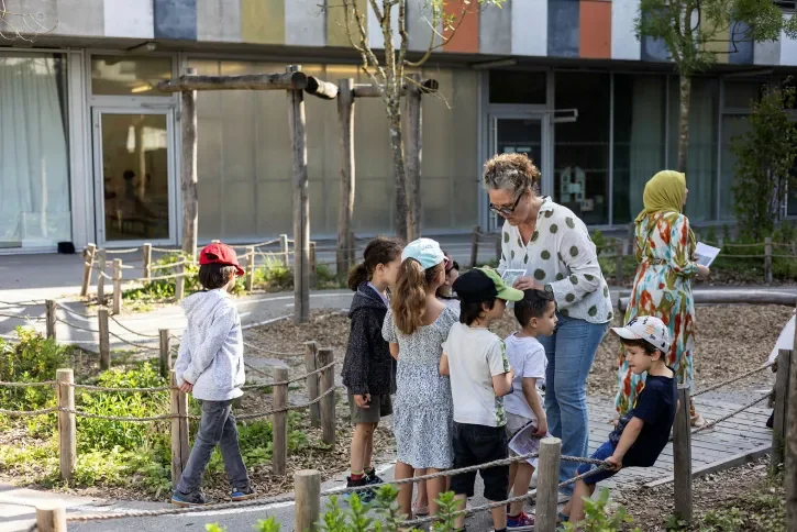 Des enfants apprennent à décrypter les plantes dans un cour d'école.