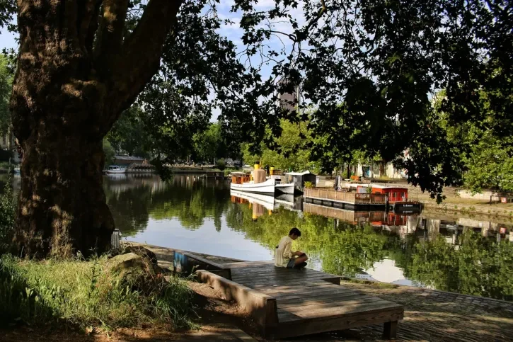 Une personne à l'ombre des arbres au bord de l'Erdre.