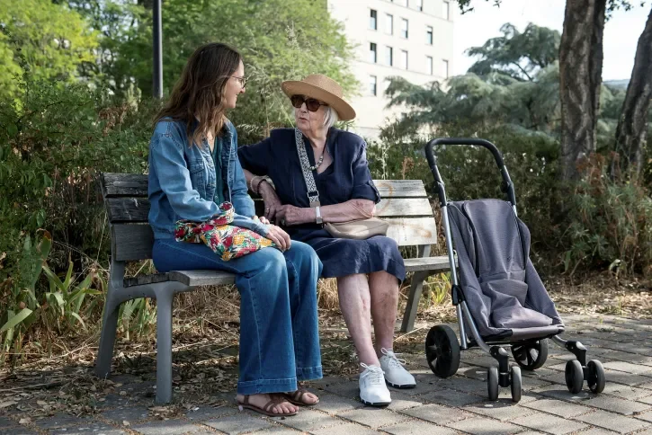 Deux personnes discutent sur un banc.