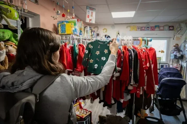 Une personne regarde un pull dans un magasin.