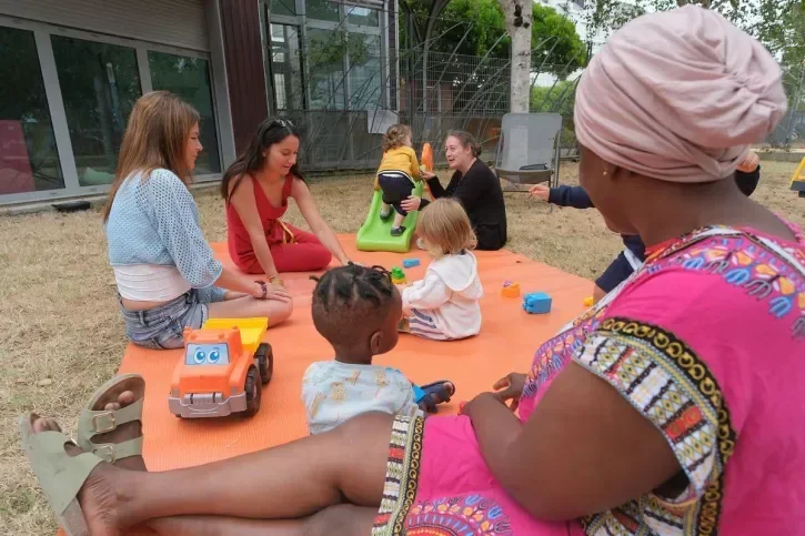 Des femmes jouent avec leur enfant.