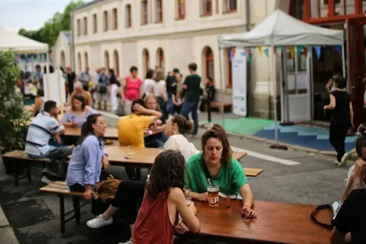 Des gens discutent devant un verre.