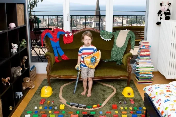 Un enfant pose avec ses jouets.
