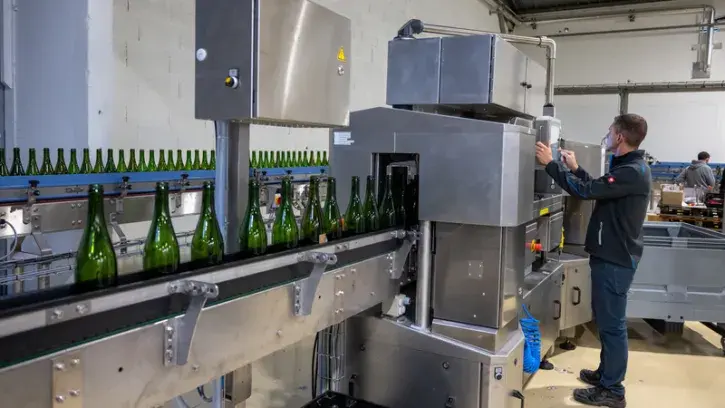 Une machine inspectrice (la 2e de France) vérifie ensuite chaque bouteille, grâce à douze caméras. Elle envoie les abîmées à la poubelle, les mal lavées retournent à la laveuse et les autres sont triées par forme et couleur pour rejoindre le bon quai d'em